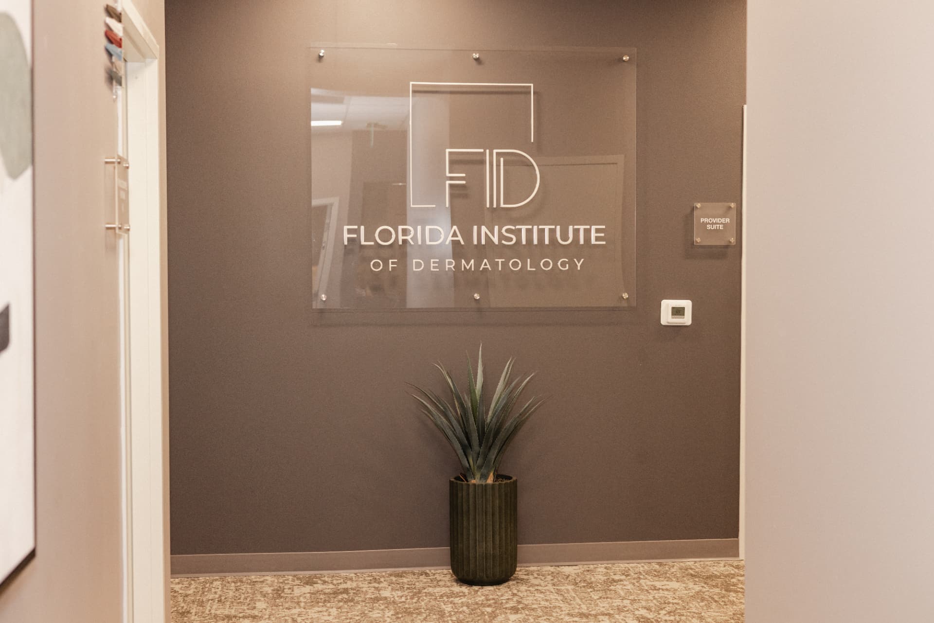 Florida Institute of Dermatology glass signage in the provider suite